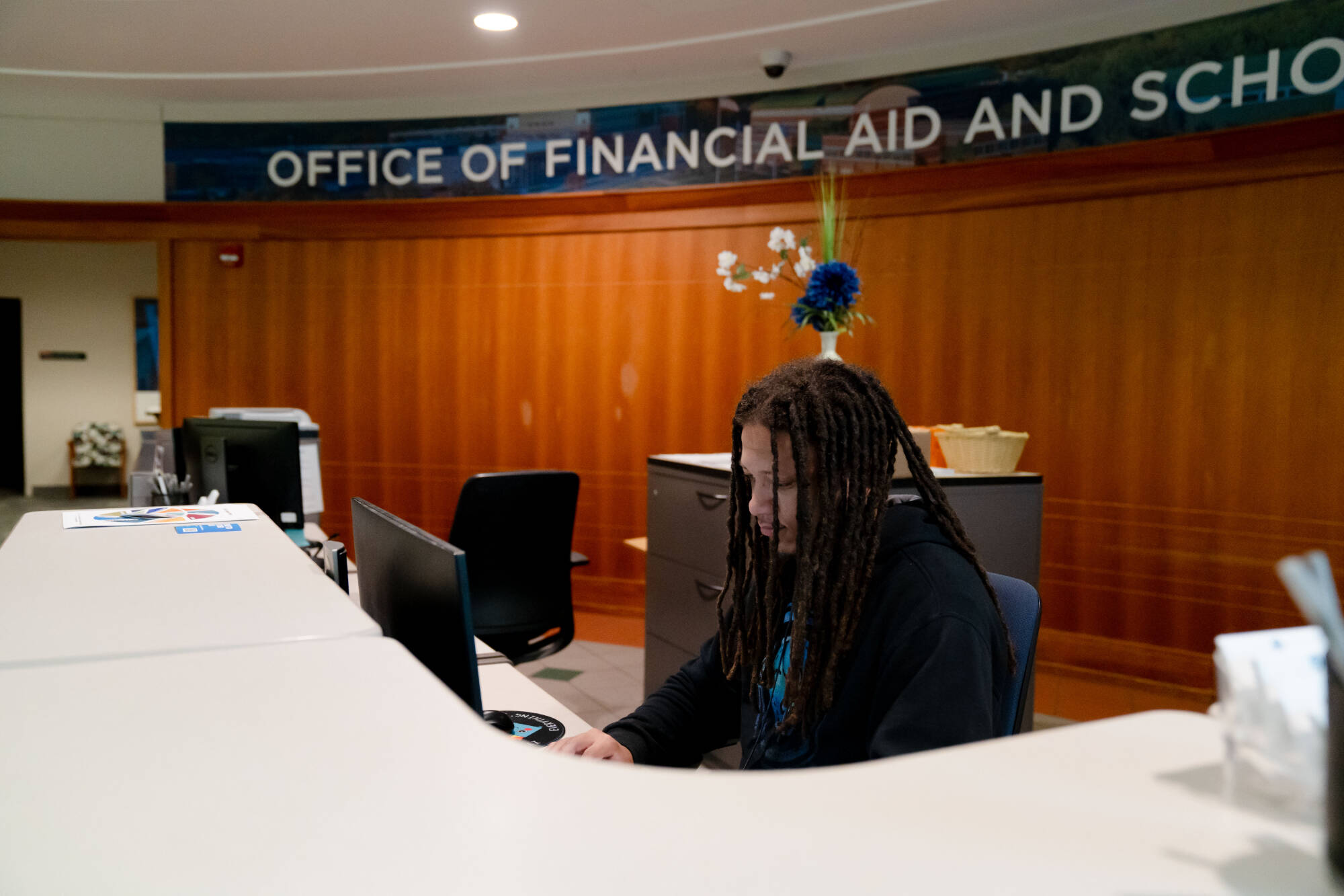 A student worker works the front desk of the Office of Financial Aid and Scholarships.